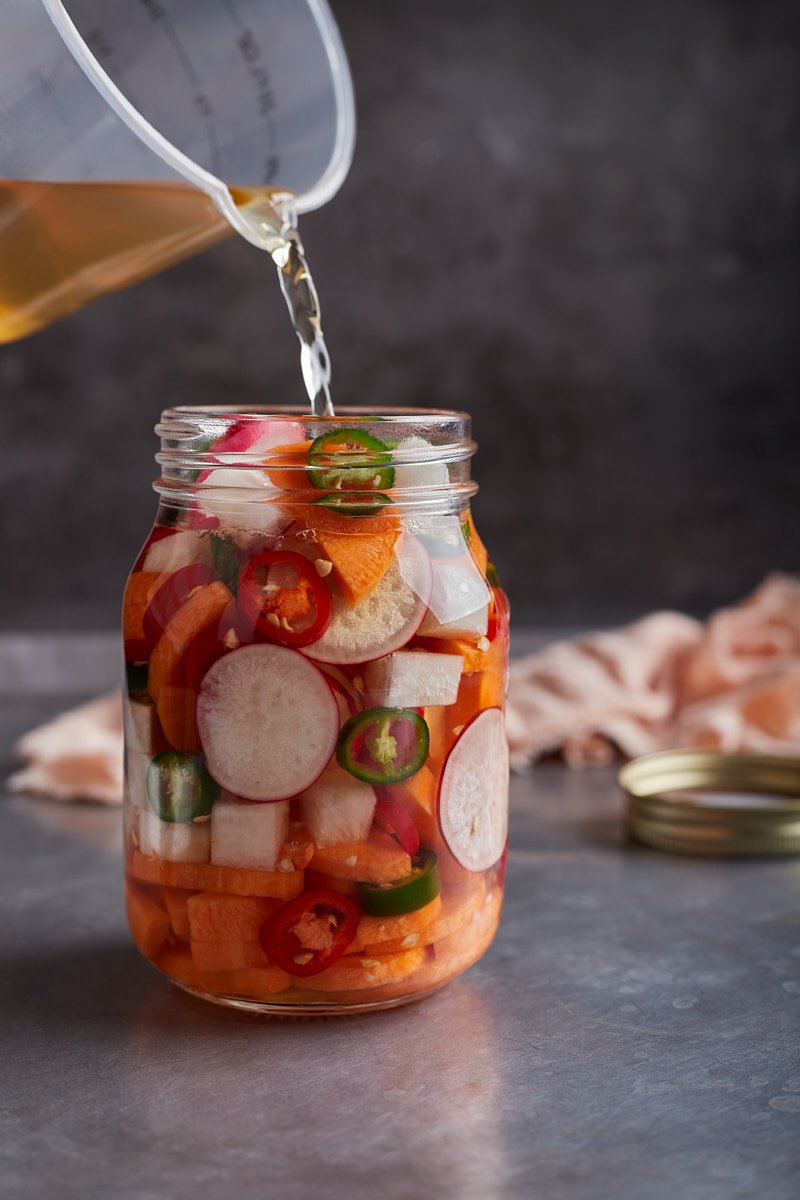 Pour pickle brine to the vegetable slices into the jar.