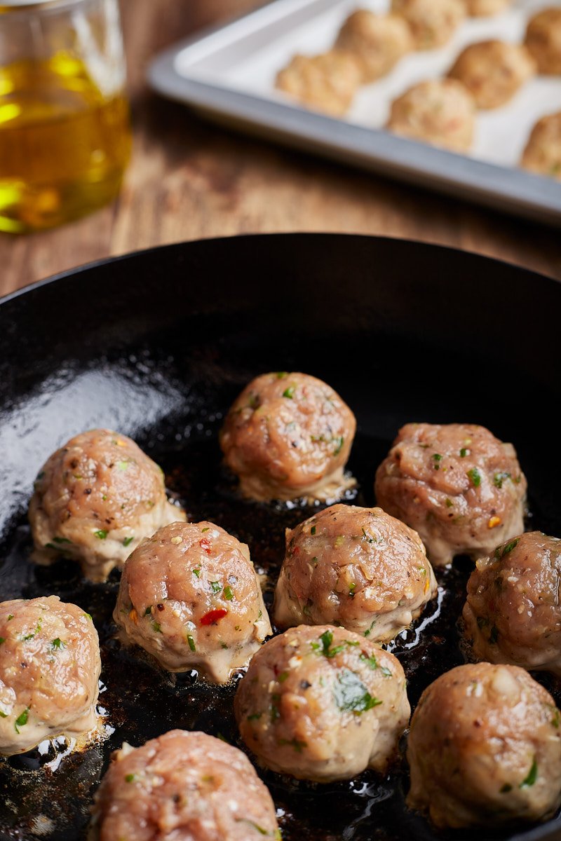To brown the meatballs in a large pan.