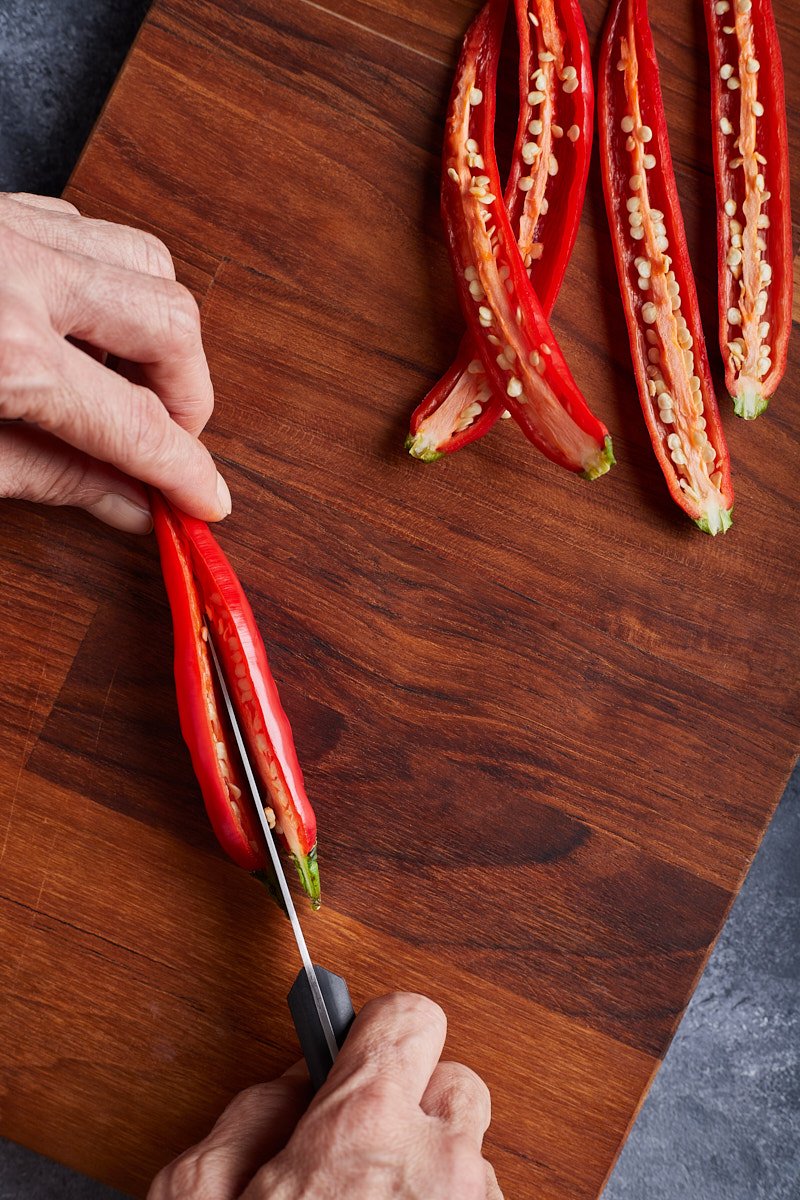 Cut the chilis in half lengthways.